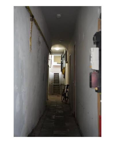 Dim hallway with arched exit and bicycle on wall